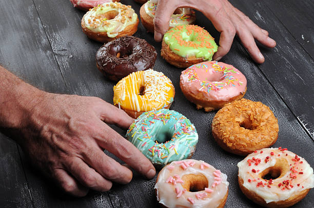 istock Fresh  donuts in soft colorful glaze on  black  wooden background 615998030