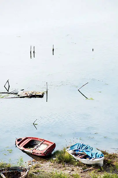 Abandoned rowing-boat on land with sea in Corfu, Greece.