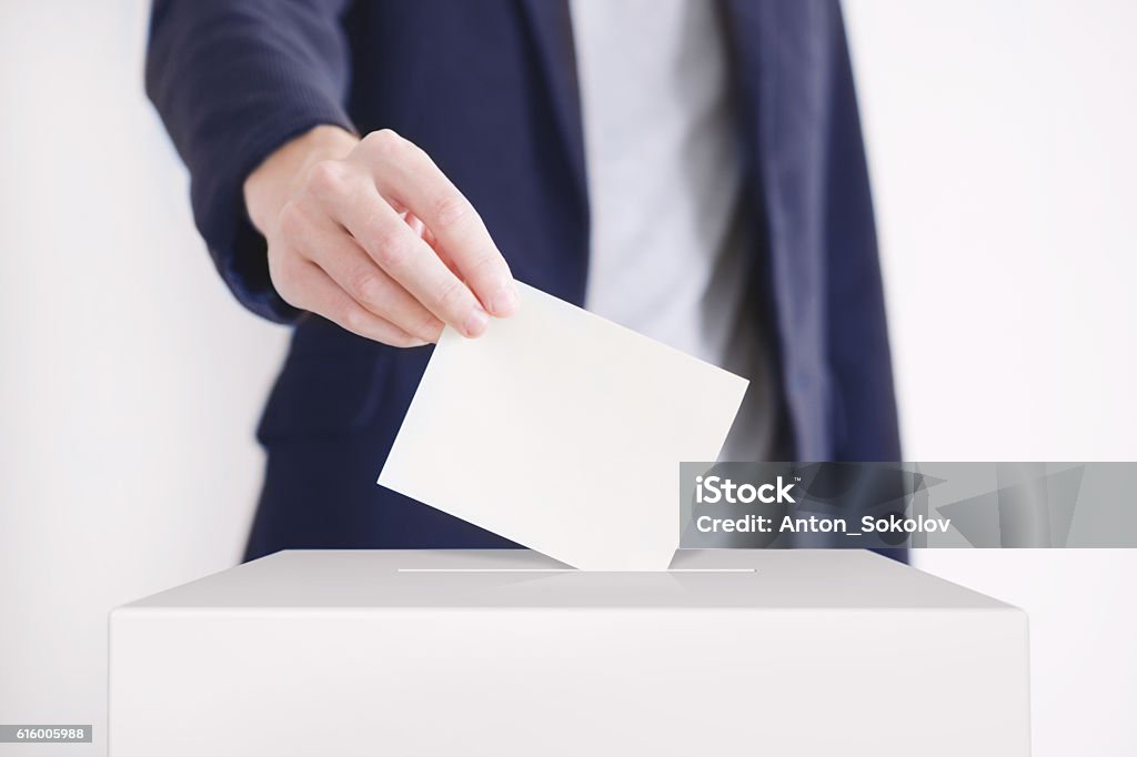 Voting. Man putting a ballot into a voting box. Voting Stock Photo