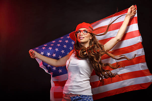 istock Girl in a baseball cap holding a US flag 616006804