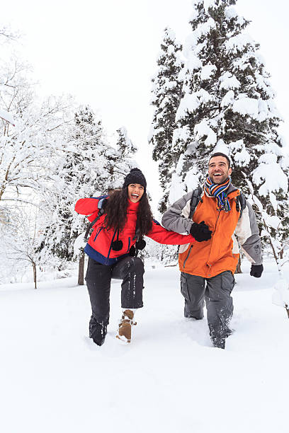 istock Young couple having fun and embracing in snow mountain 616011108