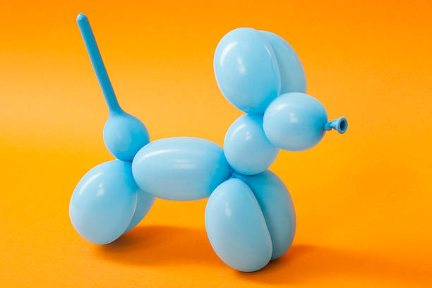 Blue balloon dog on orange stock photo