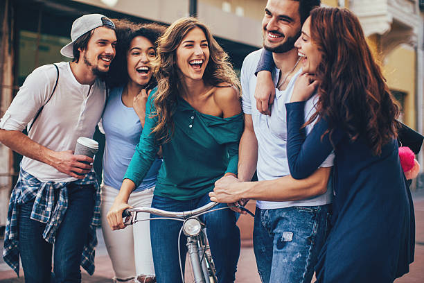 Happy people Multi-ethnic group of five cheerful young people walking outdoors hipster bike stock pictures, royalty-free photos & images