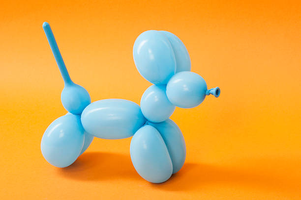 Blue balloon dog on orange stock photo