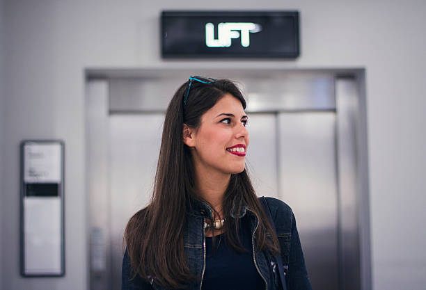 istock Smilling woman in front of elevator 616016238