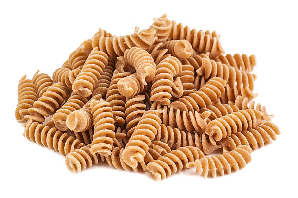 whole wheat pasta heap of whole wheat pasta on white background whole wheat stock pictures, royalty-free photos & images