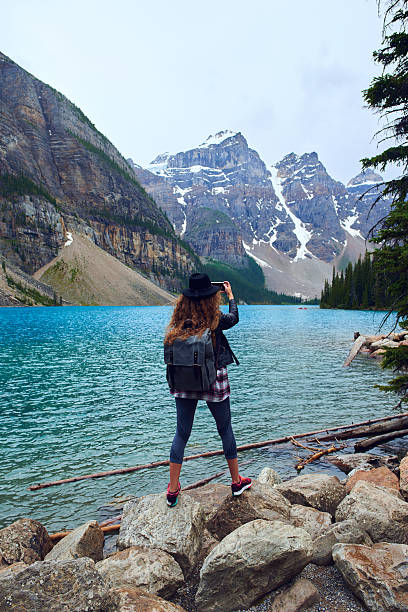 istock Young beautiful female backpacker doing pictures on her phone 616017482