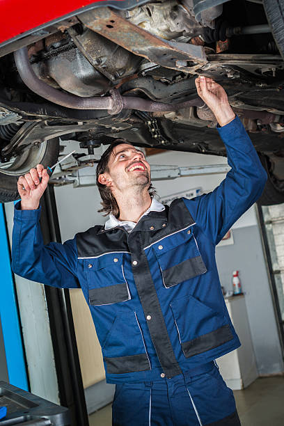 istock Mechanic checking the condition of a lifted car 616017570