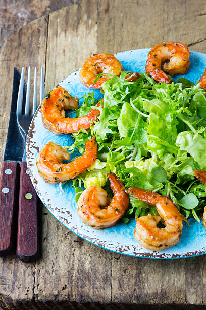 istock Seafood shrimp lettuce salad on blue plate 616018720