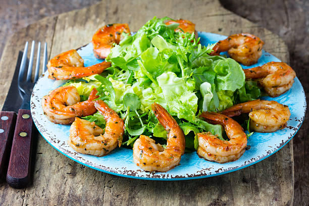 istock Seafood shrimp lettuce salad on blue plate 616018930