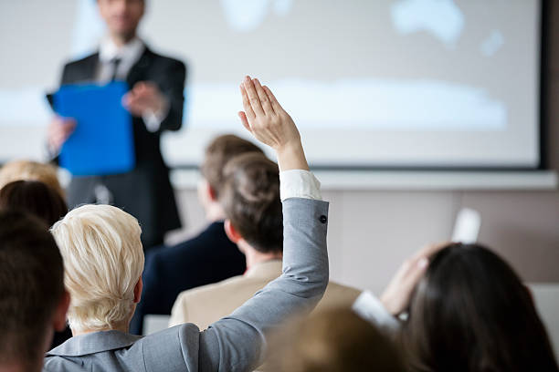 vista posteriore dell'imprenditrice che alza la mano durante il seminario - seminar asking business meeting foto e immagini stock