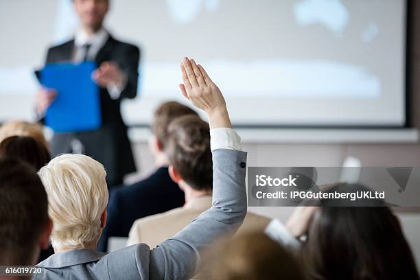 Foto de Visão Traseira De Empresária Levantando A Mão Durante Seminário e mais fotos de stock de Mão Levantada