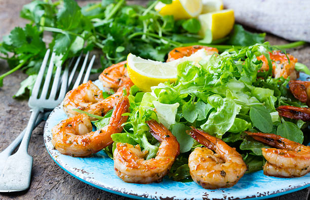 istock Seafood shrimp lettuce salad on blue plate 616019760