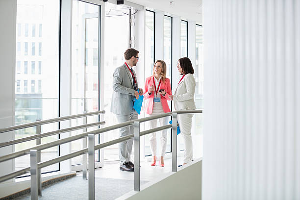 istock Business people discussing by window convention center 616020026