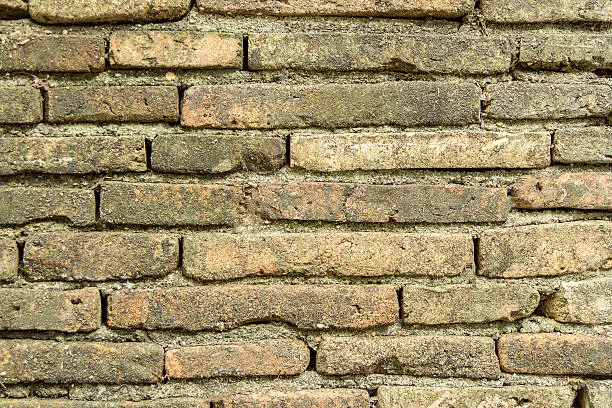 Old stone wall with herbage as background or red brick wall texture grunge background.