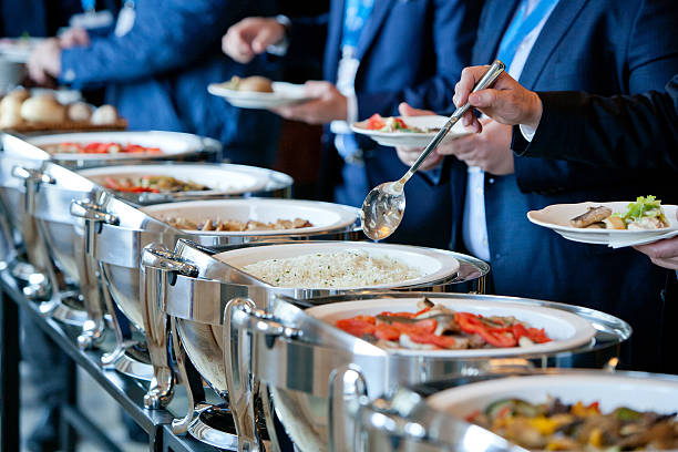 people at a banquet men in blue suits choosing food at a banquet buffet stock pictures, royalty-free photos & images
