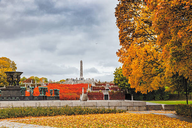 Autumn colors in Gustav Vigeland park  with the monolith sculpture. Orange  colors  in Gustav Vigeland park  with the monolith sculpture and large fountain surrounded by maple trees. A public park in  Frogner, Oslo, Norway norway autumn oslo tree stock pictures, royalty-free photos & images