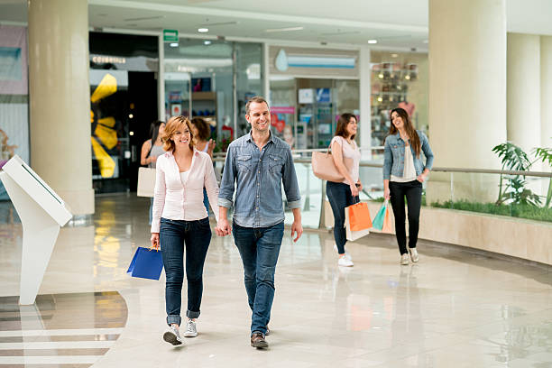 People walking at a shopping center Happy group of people walking at a shopping center - lifestyle concepts mall walker stock pictures, royalty-free photos & images