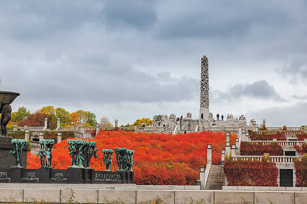 Autumn colors in Gustav Vigeland park  with the monolith sculpture. Orange  colors  in Gustav Vigeland park  with the monolith sculpture and large fountain surrounded by maple trees. A public park in  Frogner, Oslo, Norway norway autumn oslo tree stock pictures, royalty-free photos & images