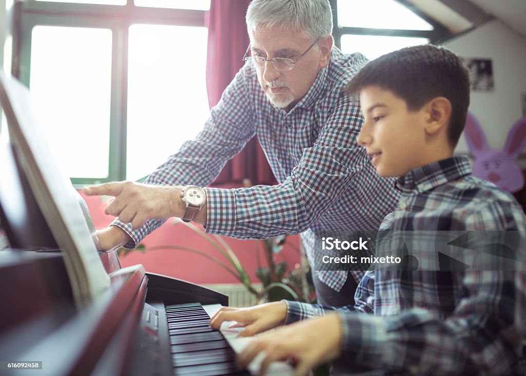 Piano class Photo man giving lesson piano to boy Instructor Stock Photo