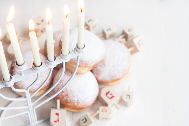 Jewish holiday Hannukah background Jewish traditional holiday Hannukah with menorah, doughnuts and dreidles. Copy paste background. hanukkah stock pictures, royalty-free photos & images