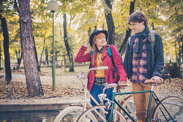 istock Young couple enjoying romantic ride with bicycle in autumn park 616092542