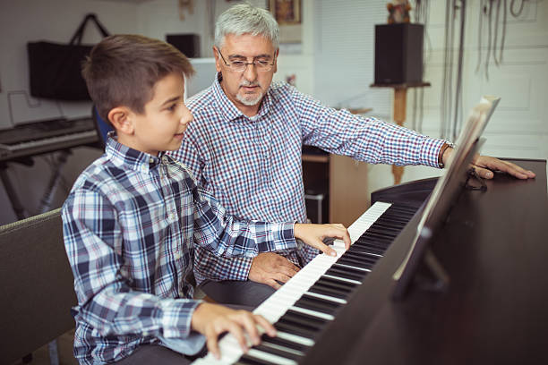 istock Boy playing piano on the class music 616092790