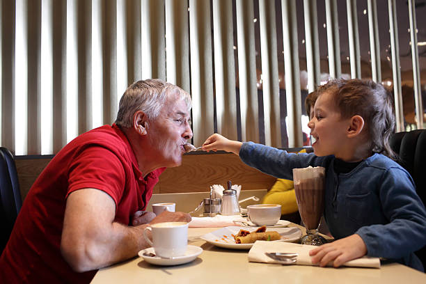 Grandchild feeds his grandfather in the restaurant