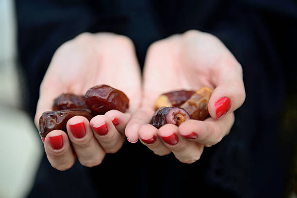 istock Emarati Arab woman holding dates in hand 616096982