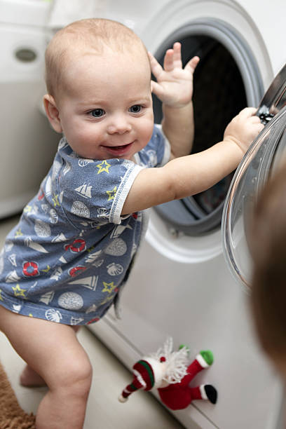 istock Smiling baby boy with washing machine 616098568