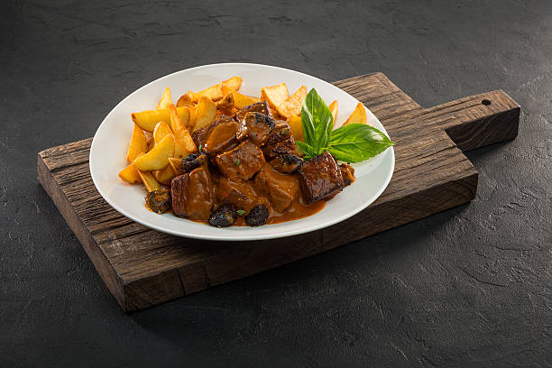 istock stew meat with potatoes and sauce on texture black background 616099414
