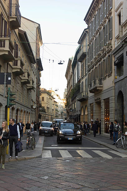 Streets of Milano, in the city centre, people passing by, trams and architecture.