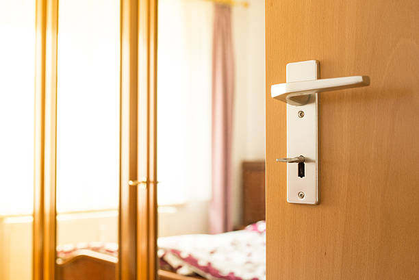 istock Open door with handle and key into a bedroom 616101608