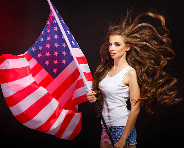 istock Girl holding US flag on a flagpole 616101650