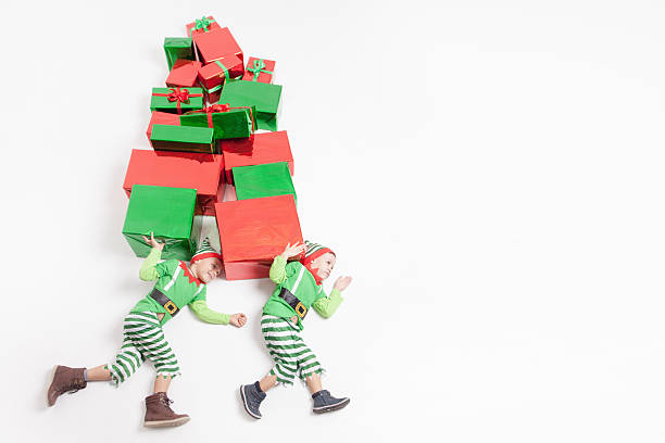 istock Boys dressed Elf costumes holding many gift boxes. Black Friday! 616102404