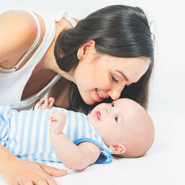 istock Happy mother holding a baby boy at white background 616102796