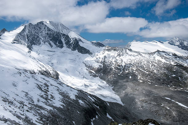 istock Snow-covered Mountains in front of Blue Sky and White Clouds 616109132