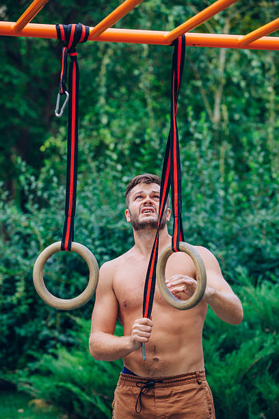 istock Muscular man exercising on outdoor gymnastic ring. 616109684
