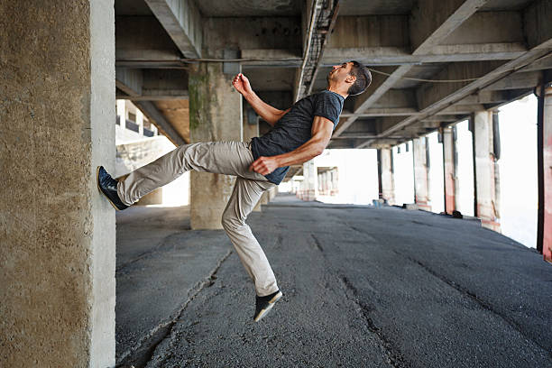 Men T-shirt of parkour in urban space. He runs up the wall. Sport in the city. Movement is life.