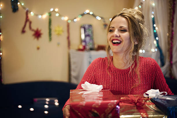 istock Happy young woman holding many present boxes in snowy night. 616111440