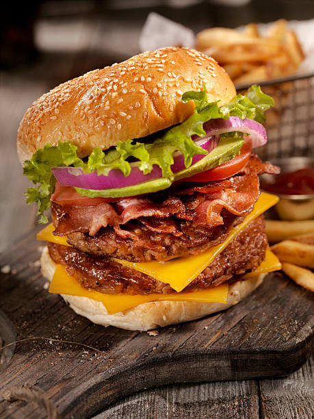 avocado bacon cheeseburger con una cesta de patatas fritas - hamburger burger symmetry cheeseburger fotografías e imágenes de stock