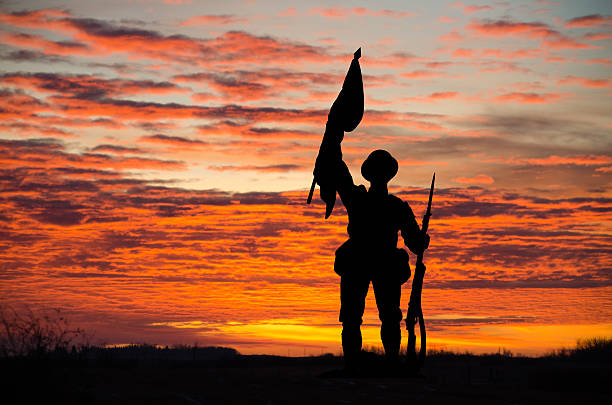istock Sunset with silhouette of a soldier and flag copy space 616114832