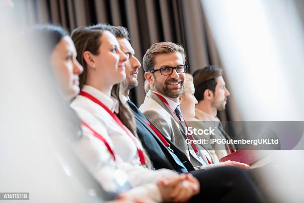 Portrait Of Confident Businessman Sitting In Seminar Hall Stock Photo - Download Image Now