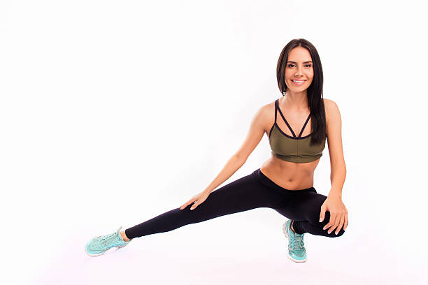 istock Young fit smiling sportswoman stretching on white background 616119042