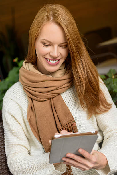 istock Cute young woman is interested in e-book 616119330
