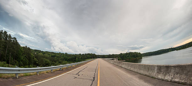 istock Wide angle of road through lake and forest 616119774