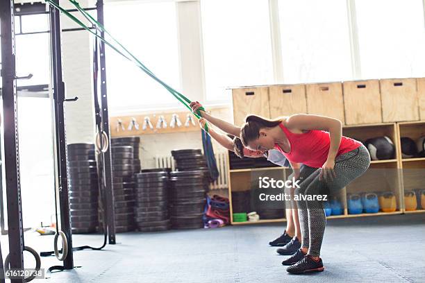 Young People Exercising With Resistance Band In Gym Stock Photo - Download Image Now