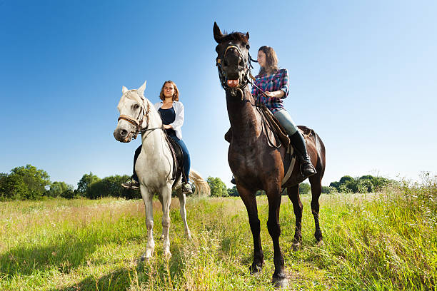 istock Two young women riding their beautiful horses 616120802