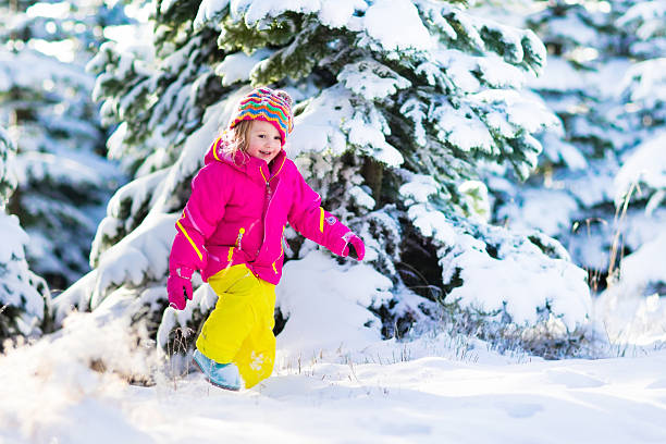 istock Child having fun in snowy winter park 616122476