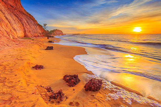 A picture of the sunrise on a small rocky beach in Aracruz, Brazil.